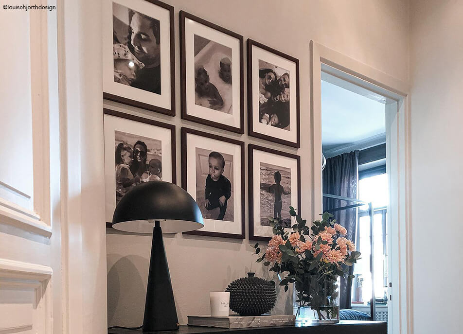 Fotosein esikus, mustvalged fotod tumedates puiduraamides